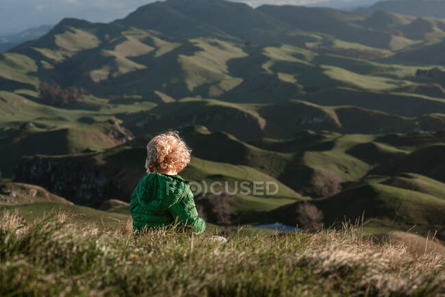 Menino sentado no topo da colina — Fotografia de Stock
