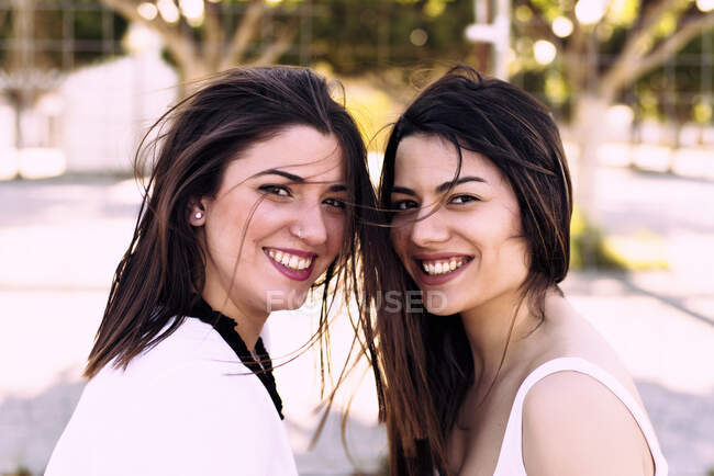 Retrato de dos amigos sonrientes posando juntos frente al camer - foto de stock