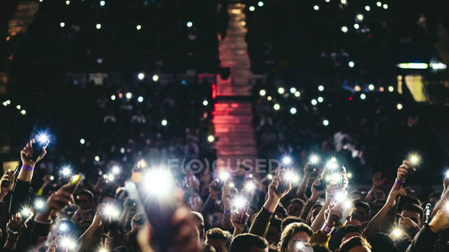 People lifting up mobile phone lights — Stock Photo