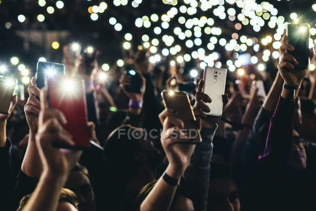 Pessoas subindo luzes do telefone móvel — Fotografia de Stock