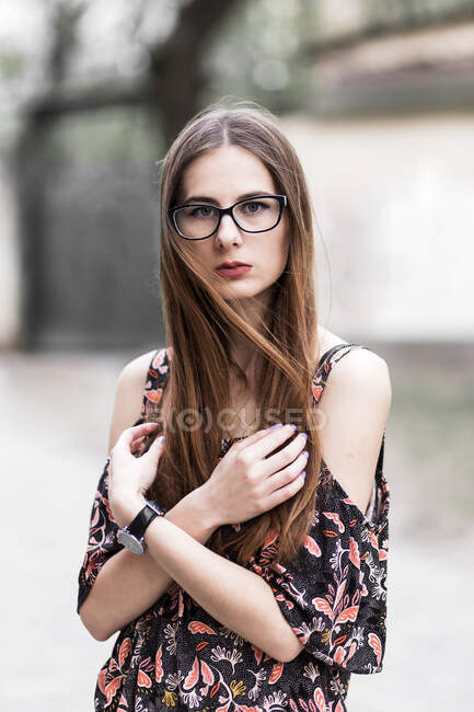 Joven de pelo castaño millennial con gafas y vestido ligero - foto de stock