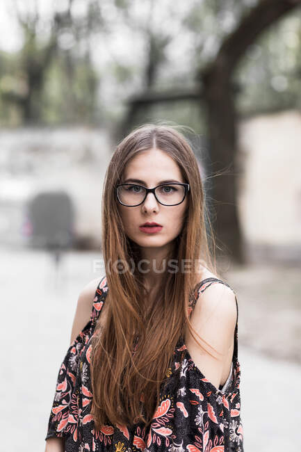 Junger braunhaariger Millennial mit Brille und hellem Kleid — Stockfoto