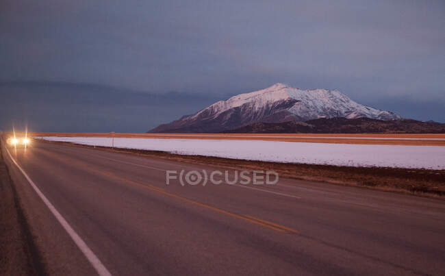 Beautiful snowy mountain and road at dusk, Utah, USA — Stock Photo