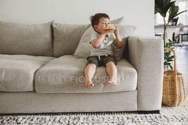 Bambino ragazzo mangiare un biscotto — Foto stock