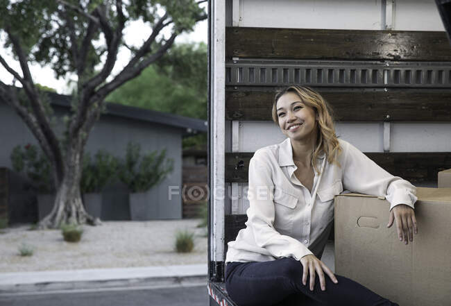 Woman Sitting Inside Moving Truck with Boxes — Stock Photo
