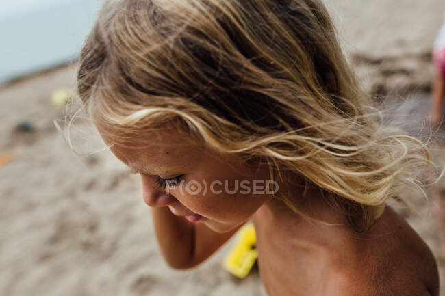 Little boy with long hair and dark eyelashes and suntan — Stock Photo