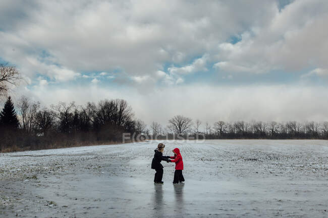 Due sorelle che giocano in un campo ghiacciato in inverno — Foto stock