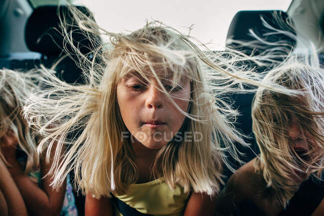 Ragazzi e ragazze sul sedile posteriore dell'auto con i capelli che soffiano nel vento — Foto stock