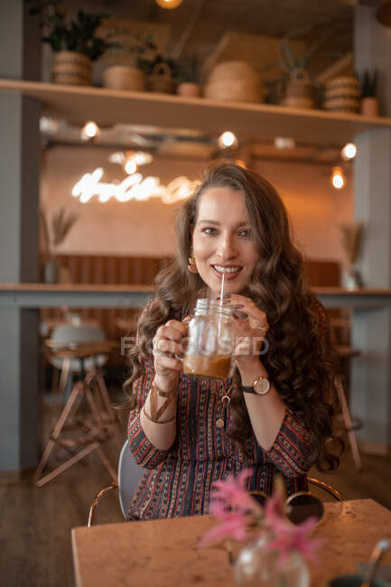 Young woman drinking coffee at coffee shop in Munich — Stock Photo