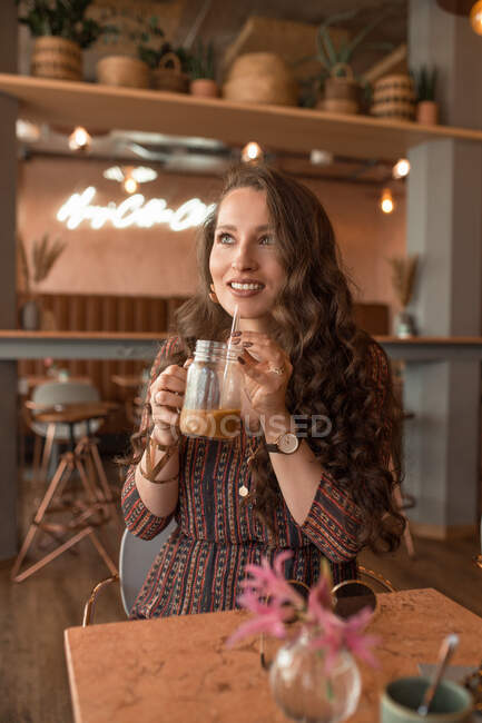 Молода красива жінка насолоджується кавою в кав'ярні — стокове фото