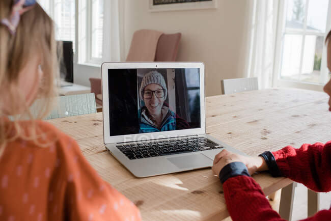Crianças tendo uma chamada de vídeo com a família enquanto isolando em casa — Fotografia de Stock