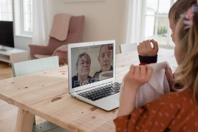 Grands-parents parlant à leurs petits-enfants sur appel vidéo — Photo de stock
