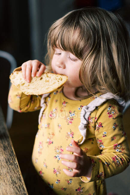 Little toddler girl enjoying homemade sourdough bread. — Stock Photo