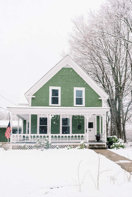 Una casa del siglo XIX en Nueva Inglaterra enterrada en la nieve en primavera. - foto de stock