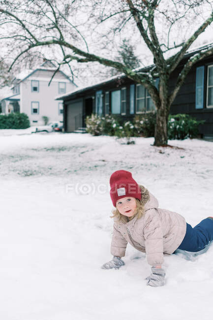 Little girl playing in the snow in spring. — Stock Photo
