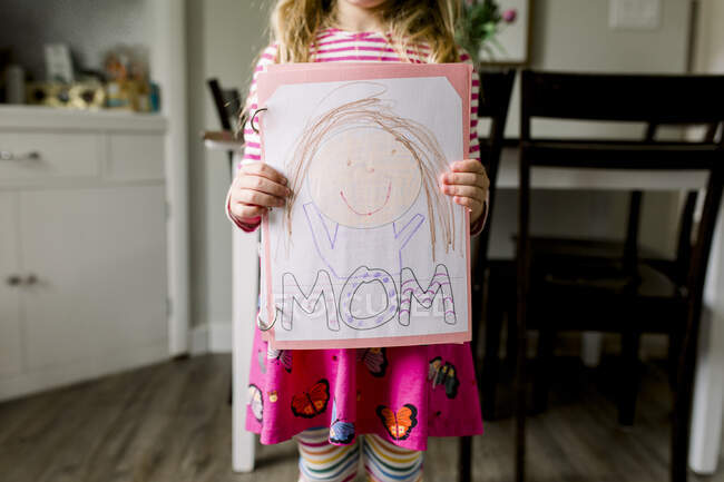 Menina segurando um desenho que ela fez de sua mãe para o Dia das Mães — Fotografia de Stock