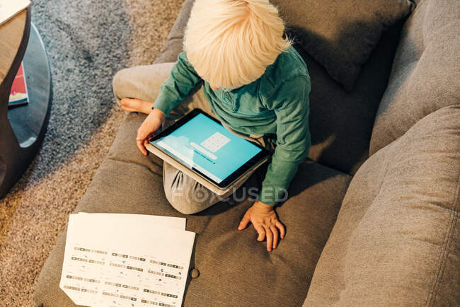 Jeune garçon travaillant sur tablette — Photo de stock