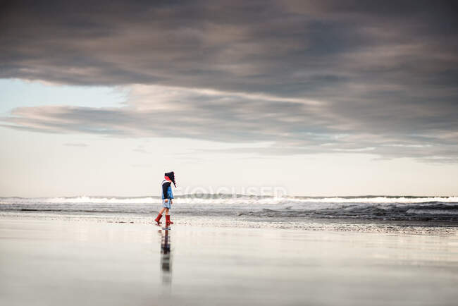 Маленький ребенок, гуляющий по холодному пляжу в Новой Зеландии — стоковое фото