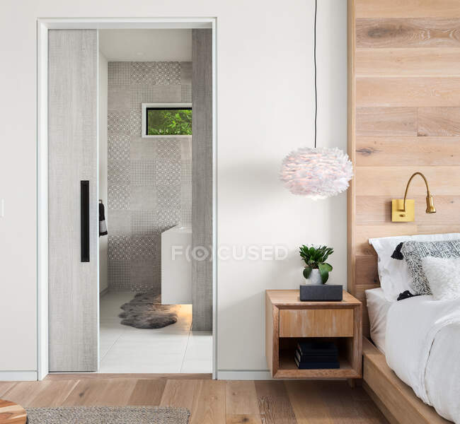 Dormitorio en nueva casa de lujo con pisos de madera, cabezal personalizado - foto de stock