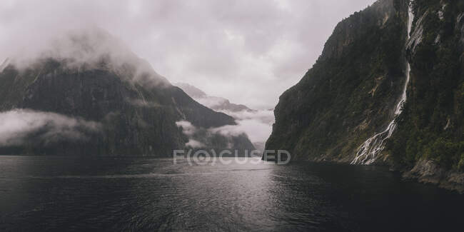 Vista panorâmica de cachoeiras e montanhas no som de Milford durante o tempo nebuloso, Nova Zelândia — Fotografia de Stock