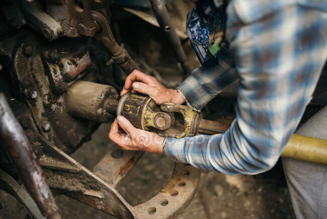 Un mécanicien est en train de réparer un tracteur agricole. — Photo de stock