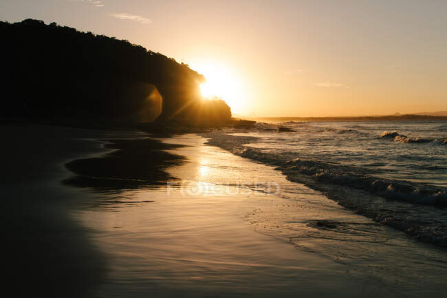 Pôr do sol na praia com vista para o mar — Fotografia de Stock
