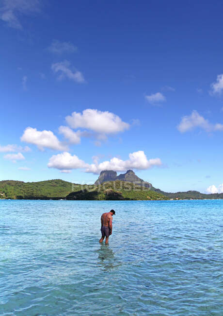 Modelo en agua en la playa de Bora Bora - foto de stock