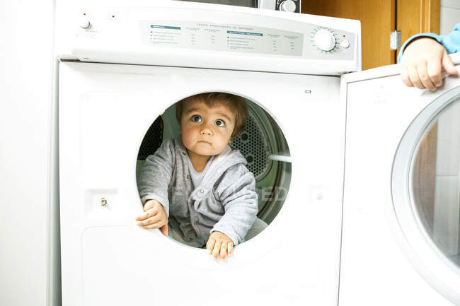 Petit enfant jouant avec la machine sèche — Photo de stock