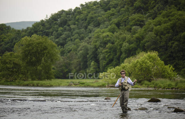 Pêcheur avec une canne à pêche sur l'étang — Photo de stock