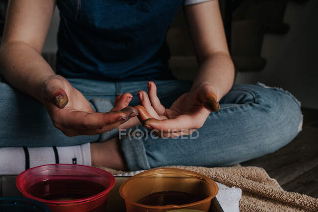 Close up of preteen's hands while dying chicken eggs — Stock Photo