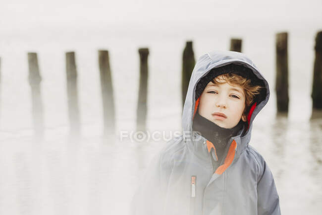 Портрет холодного хлопчика на пляжі взимку — стокове фото