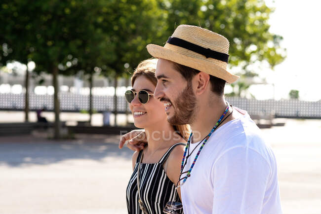 Glückliches Touristenpaar, das in einer Straße der Stadt spaziert — Stockfoto