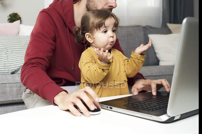 Adorable bebé con un ordenador portátil - foto de stock