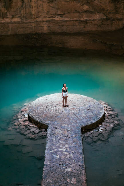 Fille dans une grotte avec un lac de cenote bleu sur le Yucatan — Photo de stock