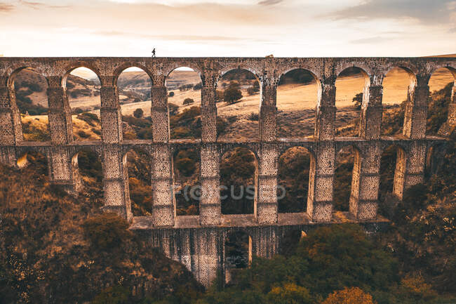 View from a drone of a girl walking on a high old bridge in Mexico — Stock Photo