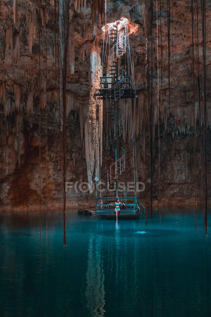 Girl in a cave with a blue cenote lake on the Yucatan — Stock Photo