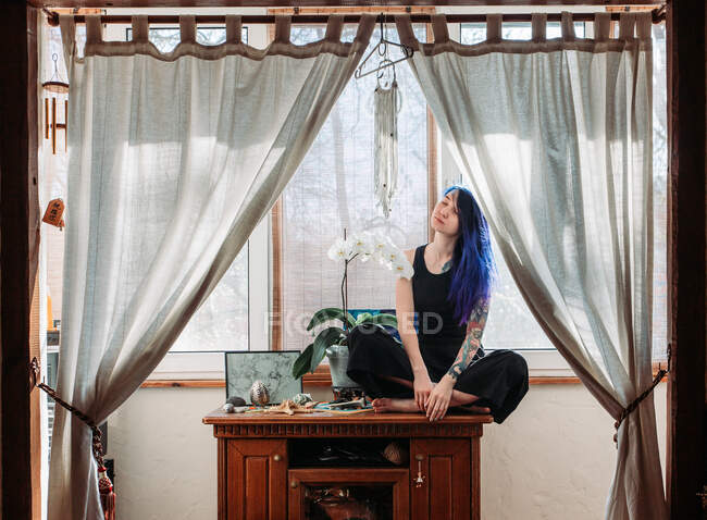 Красивая молодая женщина держит горшок растения и улыбаясь в камеру изолированы — стоковое фото