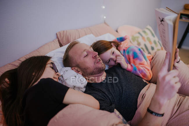 Крупним планом портрет батька, який читає своїм дочкам — стокове фото