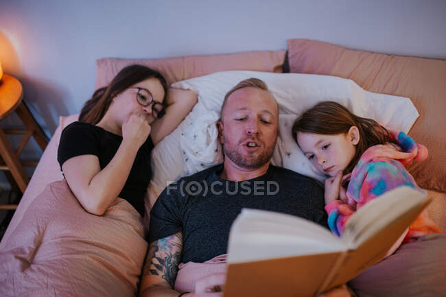 Над головой отца чтение детям — стоковое фото