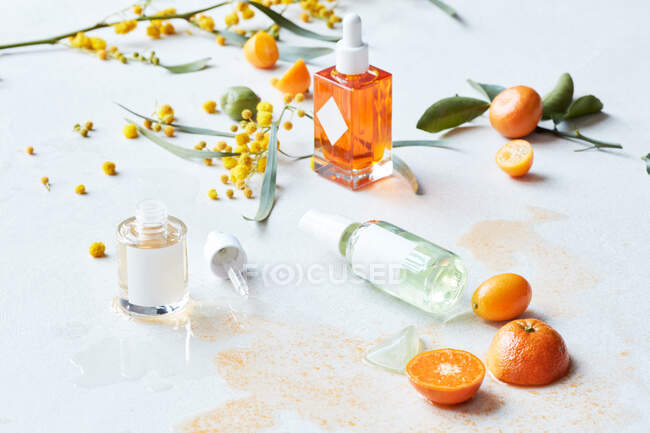 Still life display of skin care products with fruits and branches — Stock Photo