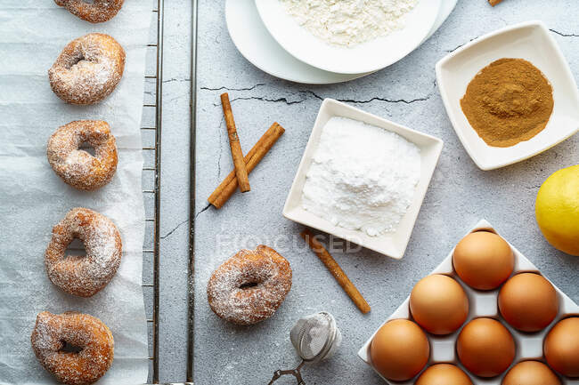 Donuts pequeños con azúcar y canela e ingredientes. Postre de rosquillas - foto de stock