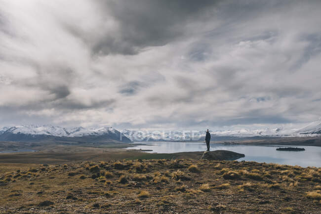 Giovane donna si erge verso le Alpi meridionali sullo sfondo della Nuova Zelanda — Foto stock
