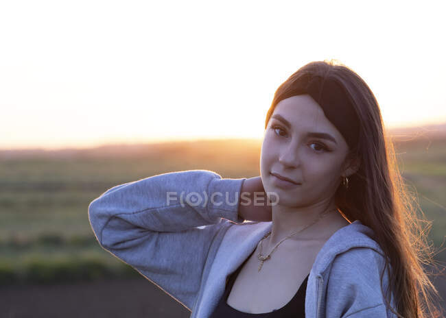 Pretty brunette girl at sunset in nature — Stock Photo