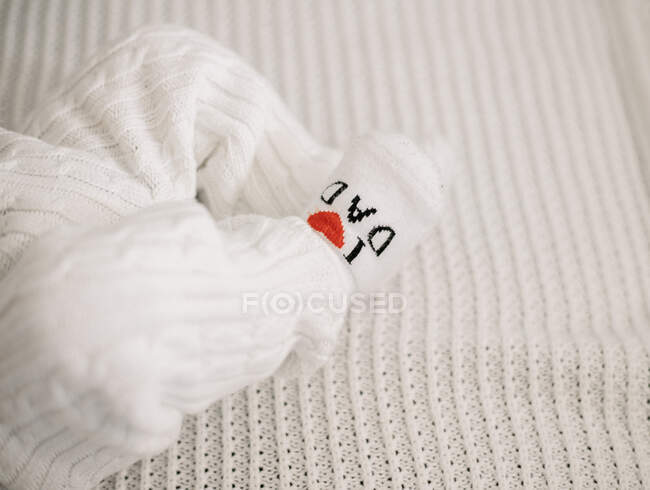 Nahaufnahme neugeborener Babybeine mit Jumpsuit und Socken — Stockfoto