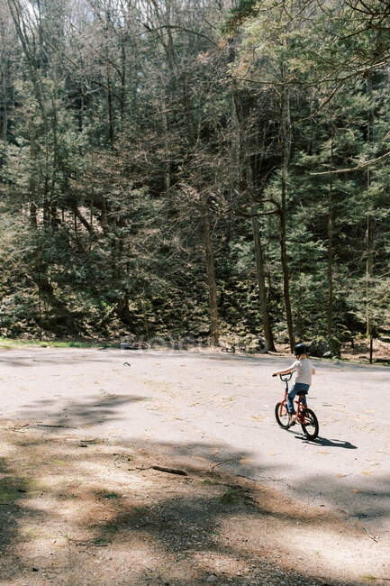 Un niño aprendiendo a andar en bicicleta sin ruedas de entrenamiento. - foto de stock