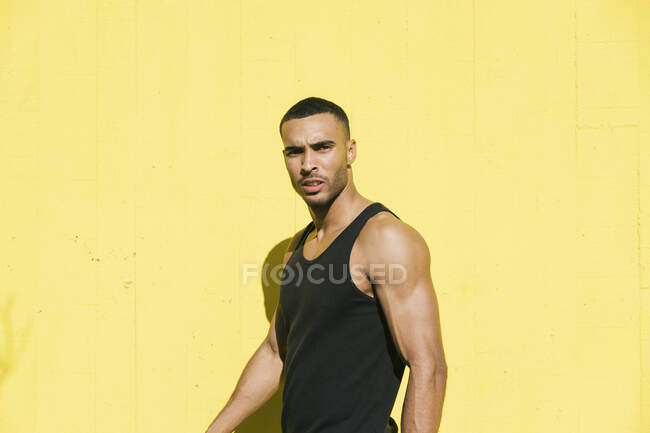 African American male athlete portrait against yellow wall — Stock Photo