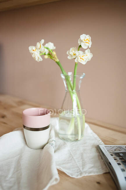 Natura morta da vicino con narciso bianco, tazza di tè, asciugamano di lino. — Foto stock