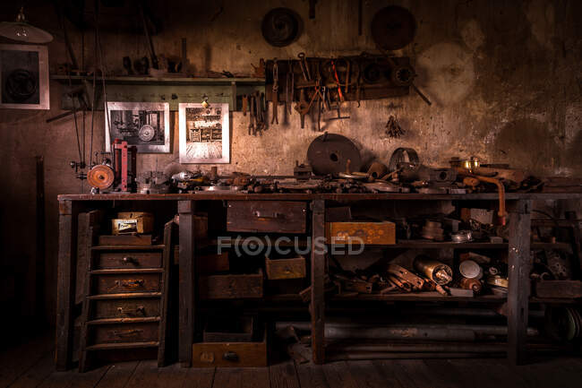 Old table in a metal workshop filled with tools — Stock Photo