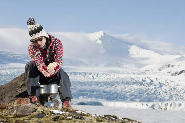 Жінка готує зовні в зимовому пейзажі — стокове фото