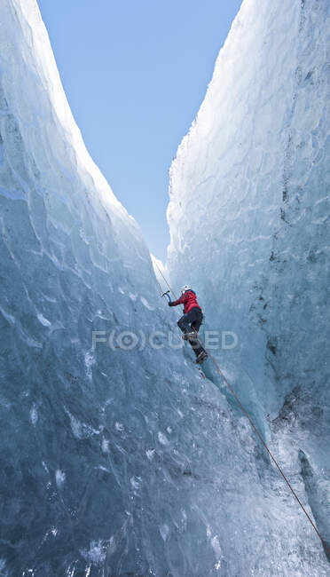 Jeune femme en équipement d'escalade escalade sur glace — Photo de stock